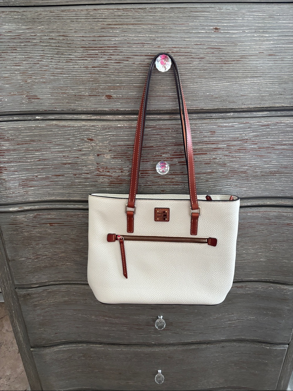 Dooney & Bourke Cream pebble leather Tote Bag with leather stitch trim.